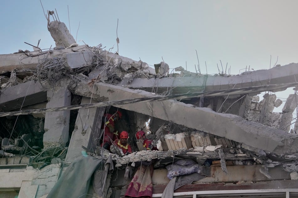 Ersthelfer inspizieren ein Wohnhaus, das bei einem früheren amerikanisch-israelischen Angriff getroffen wurde.