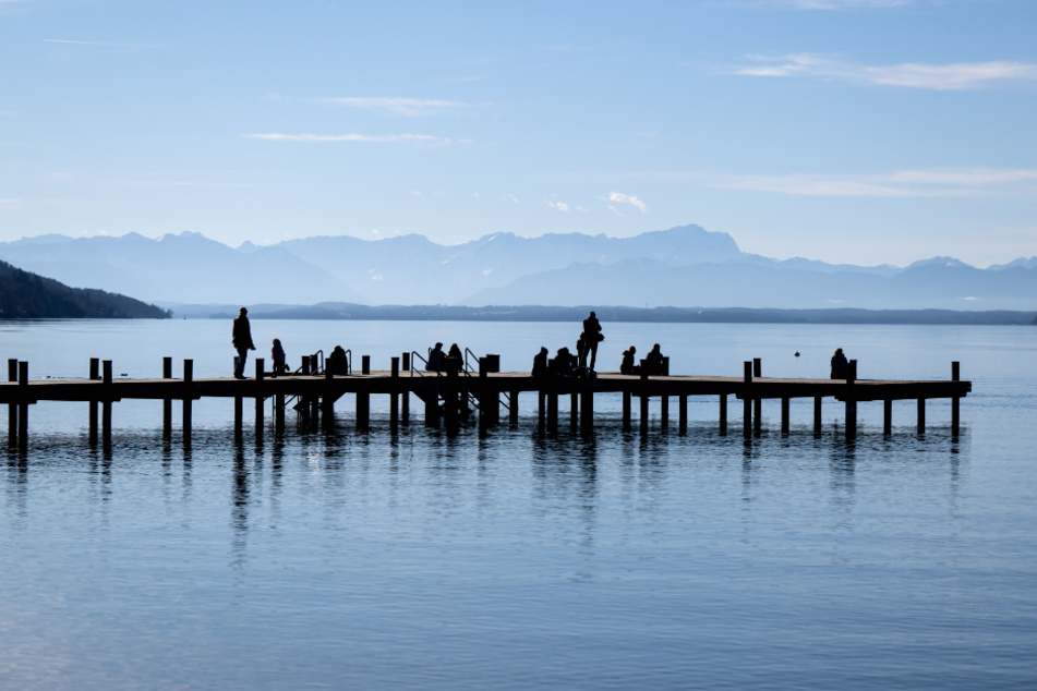 Menschen genießen das milde Wetter auf einem Steg am Starnberger See. In diesem Jahr war es in Bayern so warm wie noch nie seit Beginn der Messungen.
