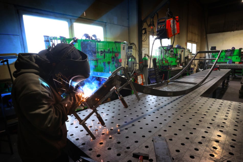 Ein Mitarbeiter des Pumptrack-Herstellers "Schneestern" schweißt in der Produktionshalle der Firma an einem Metallgerüst.