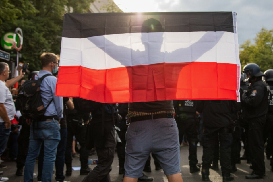 Ein Mann hält eine Reichsflagge bei einem Protest gegen die Corona-Maßnahmen vor der russischen Botschaft. (Symbolbild)