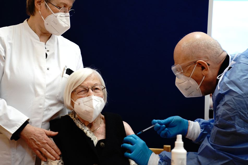 Berlin: Die 101-jährige Gertrud Haase (M) wird im Pflegeheim Agaplesion Bethanien Sophienhaus von Impfarzt Fatmir Dalladaku (r) gegen das Coronavirus geimpft, Irmgard Landgraf, Ärztin, steht links.