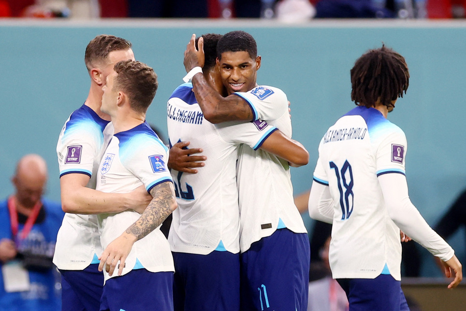 England's Marcus Rashford celebrates scoring their third goal against Wales with teammates at the 2022 World Cup.