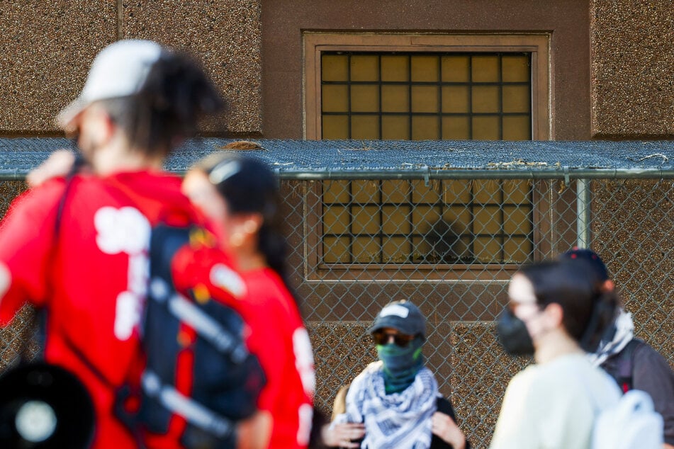 A person inside the ICE Processing Center stands next to a barred window as anti-ICE protestors demonstrate outside the holding facility on June 9, 2025 in Aurora, Colorado