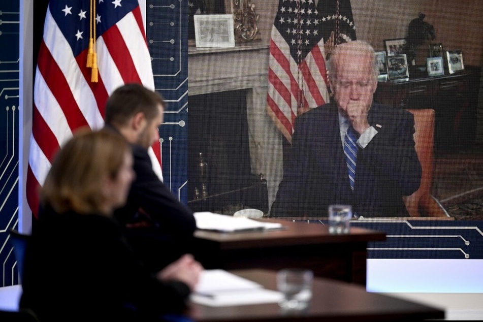 President Joe Biden covers his mouth while coughing during a virtual meeting with CEOs and labor leaders on Monday.