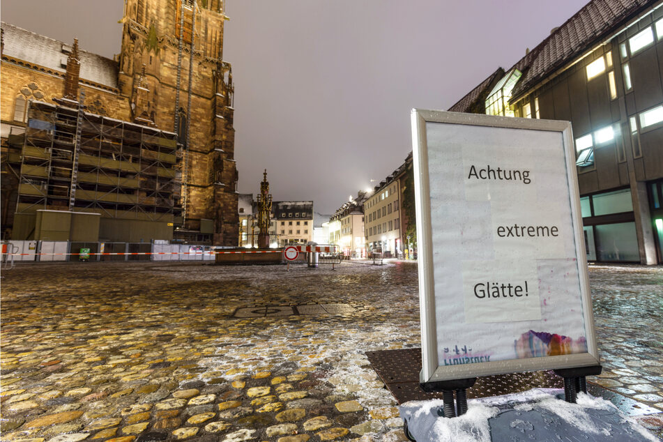 Ein Schild auf dem Münsterplatz in Freiburg warnt vor extremer Glätte.