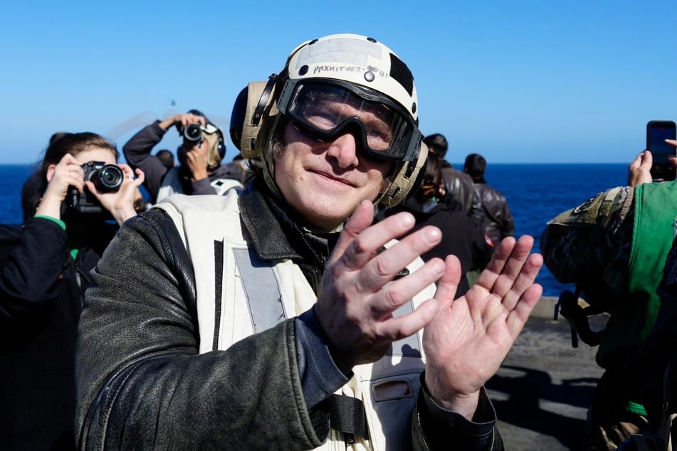Argentine President Javier Milei applauds on the deck of the USS Nimitz aircraft carrier while sailing in Argentine waters near the city of Mar del Plata, Buenos Aires province, during the Passex 2026 naval exercises on April 30, 2026.