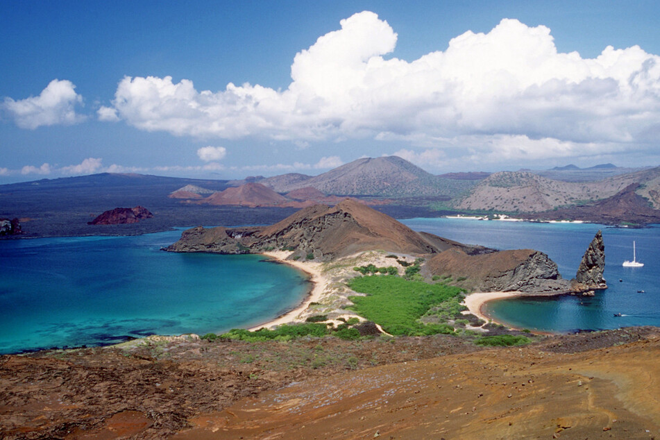 Blick von der Galápagos-Insel Bartolomé auf die berühmte Felsennadel "Pinnacle Rock" bei San Cristóbal.