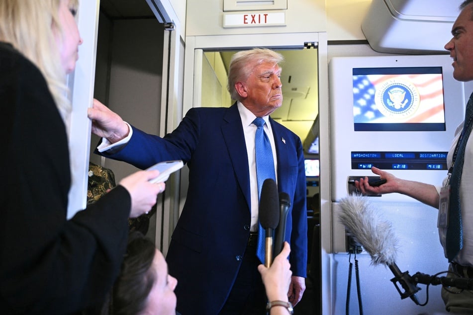 President Donald Trump speaks to members of the media accompanying him aboard Air Force One on May 16, 2025.