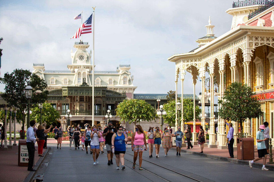 Gäste des Freizeitparks "Walt Disney World" gehen durch den Park am Tag der Wiedereröffnung.