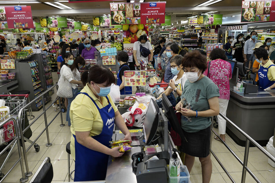 Zahlreiche Kunden tragen in einem Supermarkt in Hongkong einen Mundschutz.