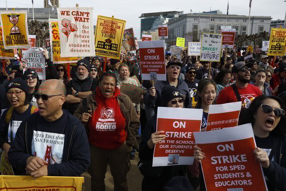 Teachers with the San Francisco Unified School District hold signs during a rally outside of City Hall on the first day of their strike on February 9, 2026.