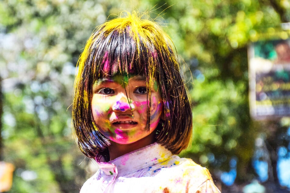 Ein mit Farben besprühtes Mädchen nimmt an den Feierlichkeiten zum Holi-Festival in Kalkutta, Indien teil.