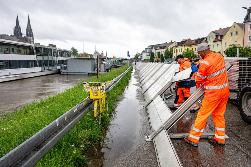 Schutzwände werden in der Regensburger Altstadt am Donauufer aufgebaut.