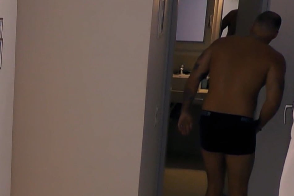 Credo (25) lugt in das Zimmer, in dem Marc-Robin gerade nackt mit Laura unter der Dusche steht.