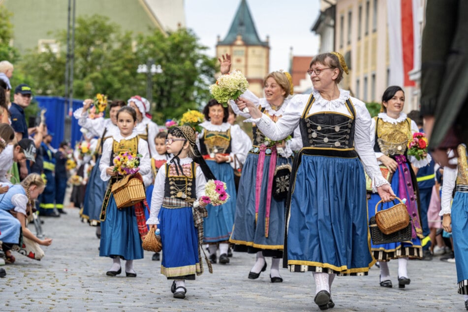 Teilnehmer des traditionellen Auszugs zum Gäubodenvolksfest gehen in Tracht durch die Innenstadt.