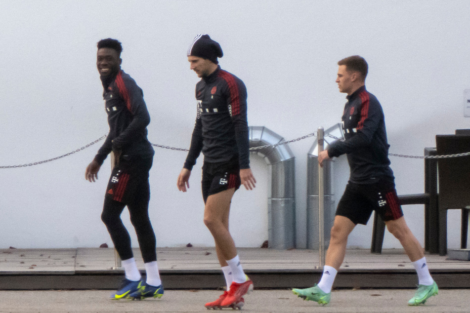 Alphonso Davies (l-r), Leon Goretzka und Joshua Kimmich gehen gemeinsam zum Trainingsstart des FC Bayern im neuen Jahr.