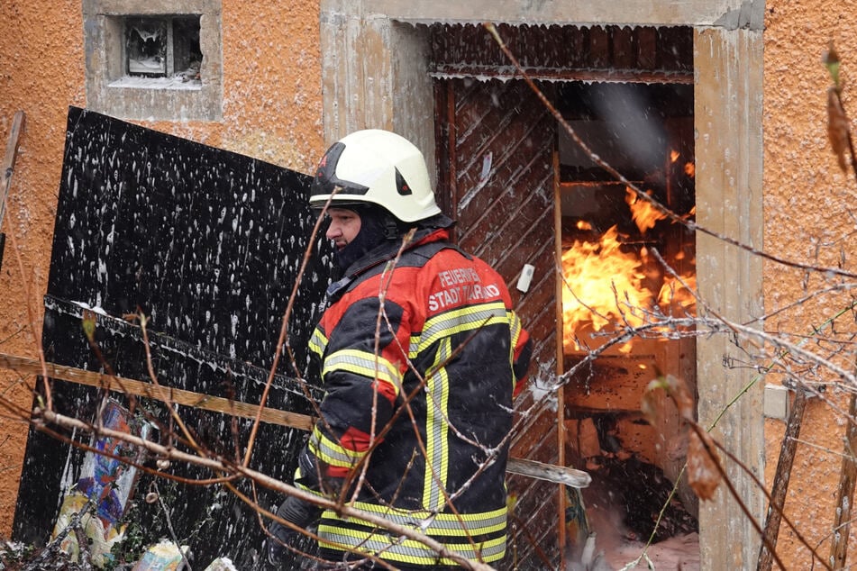 Ein Feuerwehrmann trägt ein unvollendetes Gemälde nach draußen.