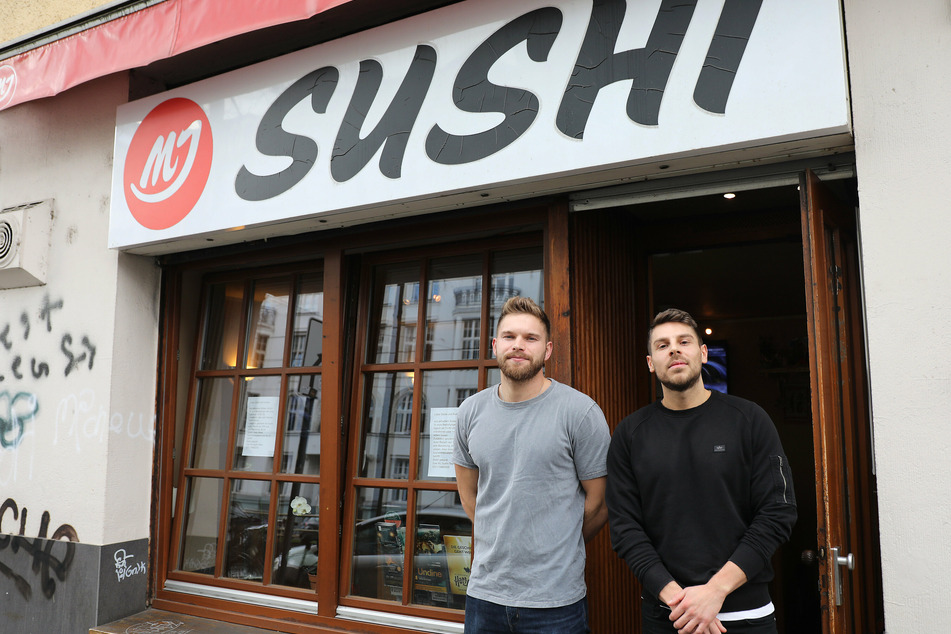 Sinan Bartsch und Oliver Noster (r) stehen vor ihrer geschlossenen Sushi Bar in Köln.