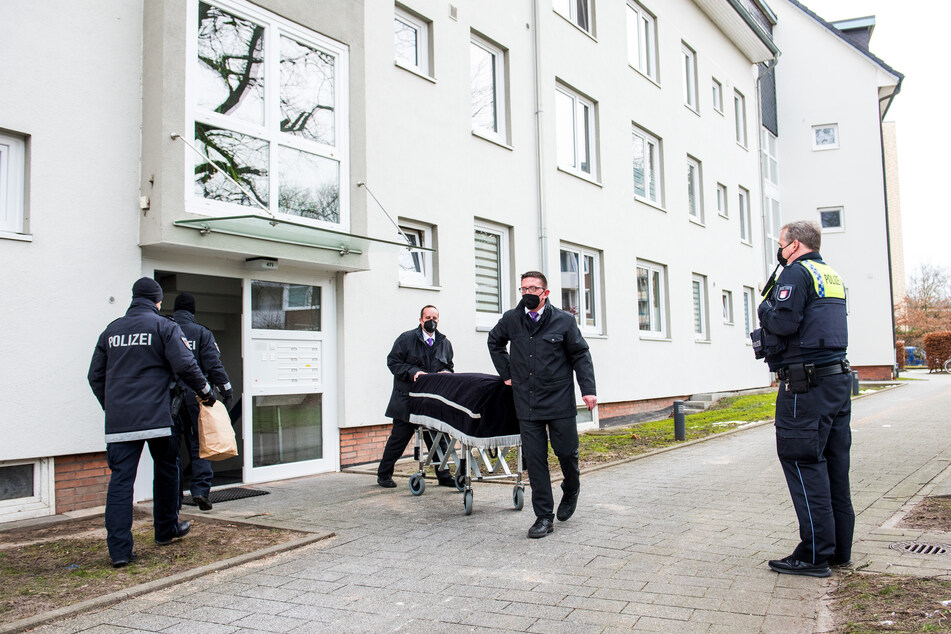 Bestatter transportieren im Stadtteil Bramfeld einen Sarg aus einem Mehrfamilienhaus ab.