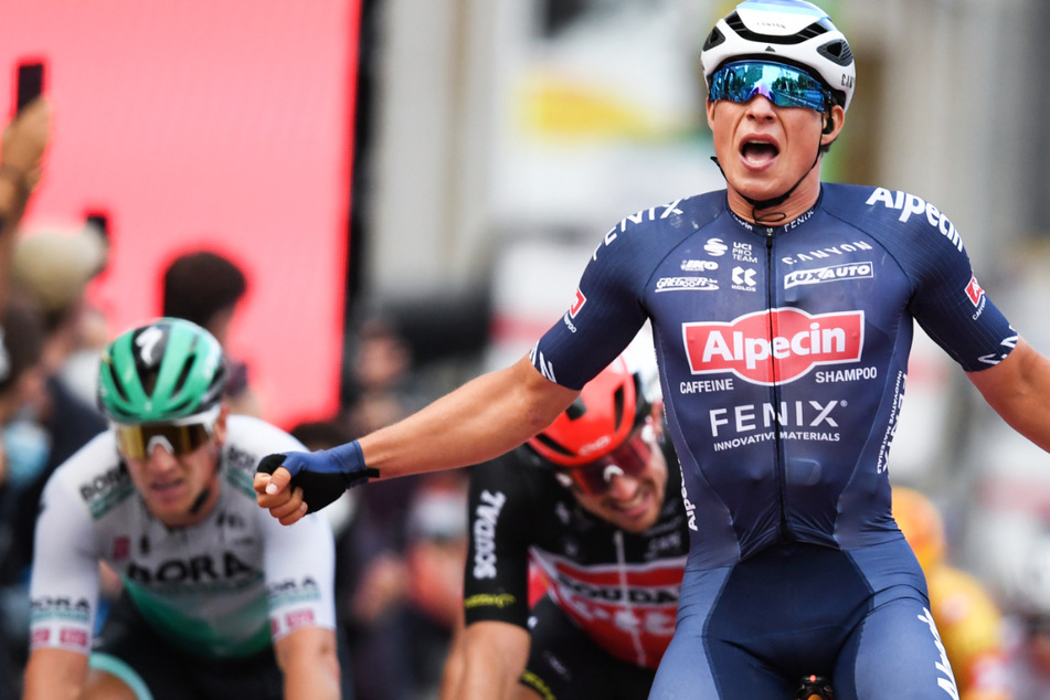 Jasper Philipsen (23, r) vom Team Alpecin Fenix jubelt im Ziel an der Alten Oper vor John Degenkolb (32, 2.v.l.).