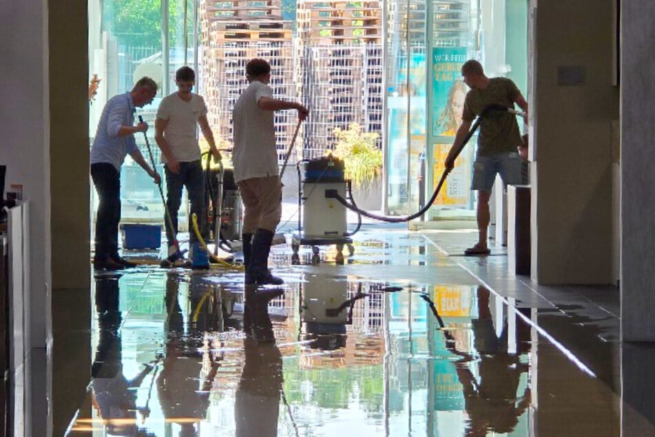 Fleißige Helfer kümmern sich darum, den Wasserschaden bei Möbel Ehrmann in Landau zu bekämpfen.