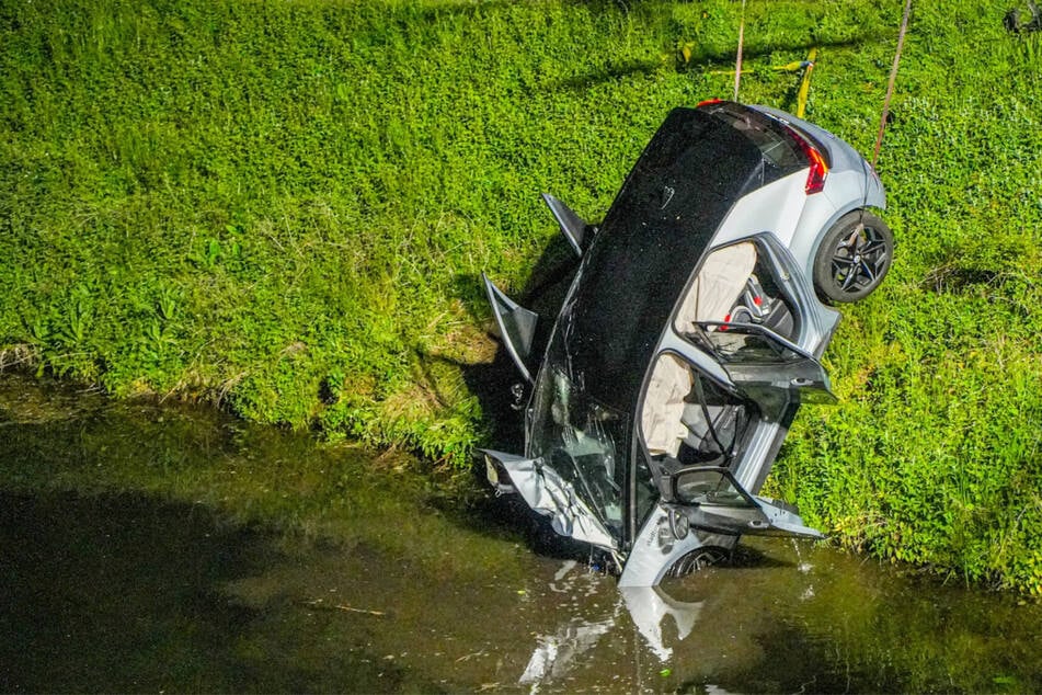 Carsharing-Auto landet kopfüber in Kanal: Kran muss Wagen herausziehen