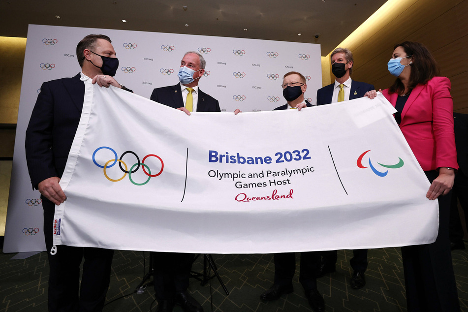 Members of the Brisbane 2032 delegation hold a banner commemorating their award to host the 2032 Summer Olympic Games