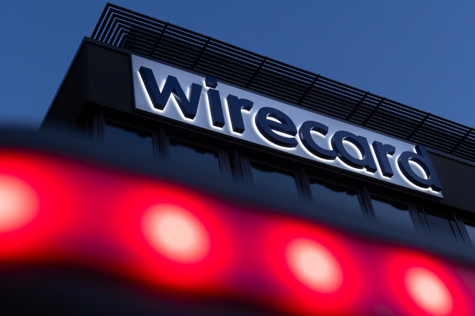 Rote Lichter leuchten vor dem Schriftzug von Wirecard an der Firmenzentrale des Zahlungsdienstleisters in München-Aschheim.