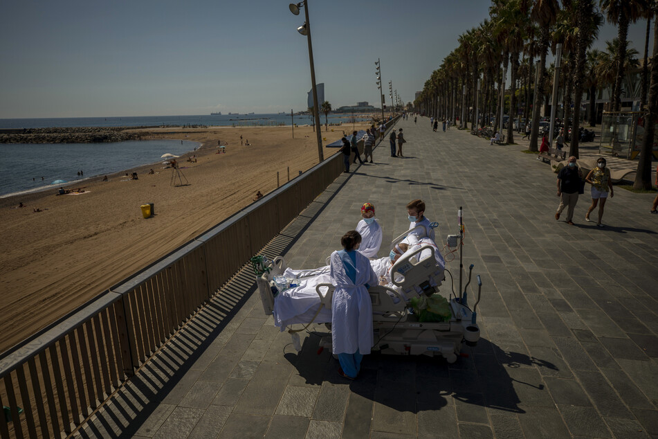 Francisco Espana, 60 Jahre alt, ist von Mitgliedern seines Ärzteteams umgeben, als er von einer Promenade neben dem Hospital del Mar in Barcelona auf das Mittelmeer blickt. Francisco verbrachte aufgrund einer Corona-Infektion 52 Tage auf der Intensivstation des Krankenhauses, doch am Freitag wurde ihm von seinen Ärzten erlaubt, im Rahmen seiner Genesungstherapie fast zehn Minuten am Meer zu verbringen.