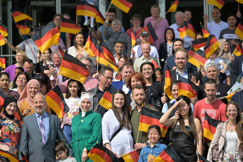 Ab sofort glückliche Deutsche: Beim Gruppenbild zum Fest winkten viele der Eingebürgerten mit Fahnen in Schwarz-Rot-Gold.