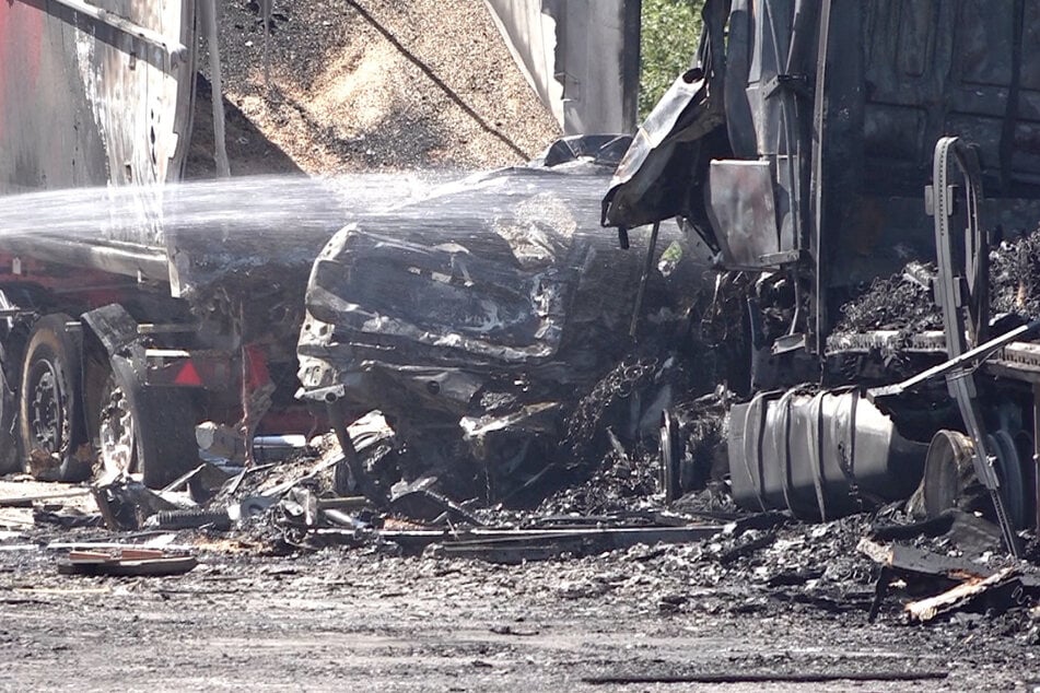 Ein Auto mit Wohnwagen wurde zwischen zwei Lkw eingeklemmt und brannte völlig aus. Die Polizei rechnet mit mehreren Toten.