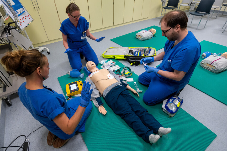 Die angehenden Mediziner Sylvi Frydetzki (l-r), Julia Enselait und Christian Etzrodt versorgen einen Notfallpatienten, der durch eine Puppe dargestellt wird, im neuen "Skills Lab" im Klinikum Chemnitz.
