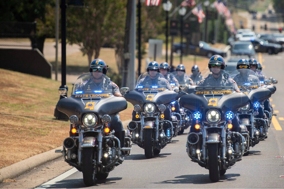A motorcade carrying six former law enforcement officers who pleaded guilty to state charges leaves the Rankin County Courthouse and rides down US Highway 80 in August 2023.