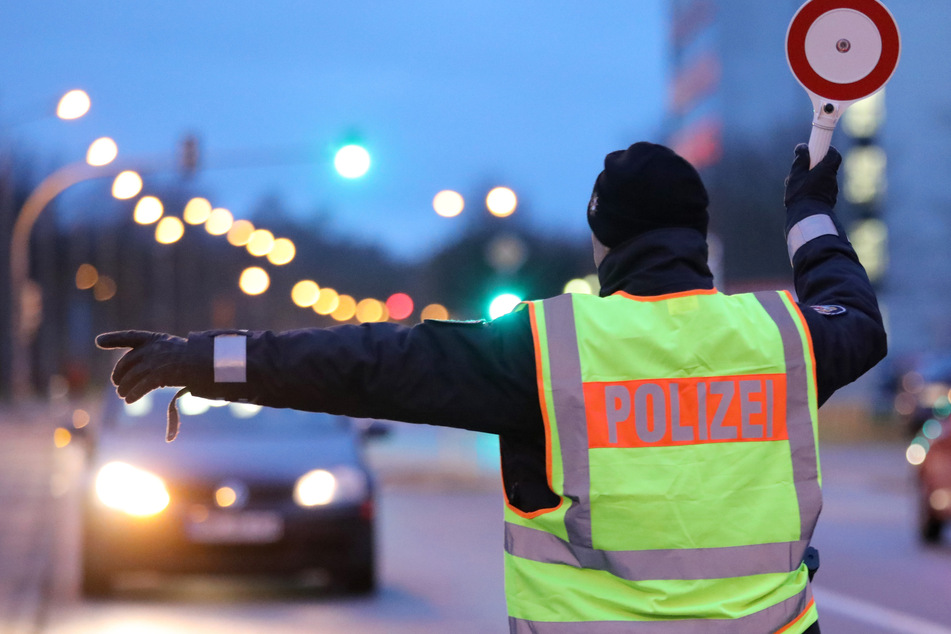 Ein Polizist winkt ein Auto für eine Verkehrskontrolle heraus. (Symbolfoto)