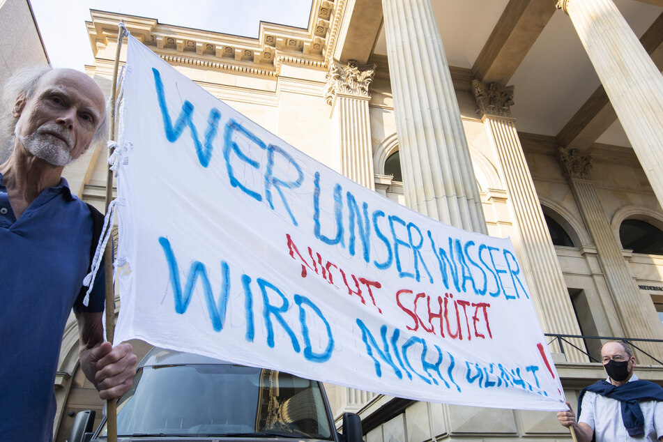 Die Bürgerinitiative "Unser Wasser" aus Lüneburg demonstriert mit einem Banner vor dem niedersächsischen Landtag.