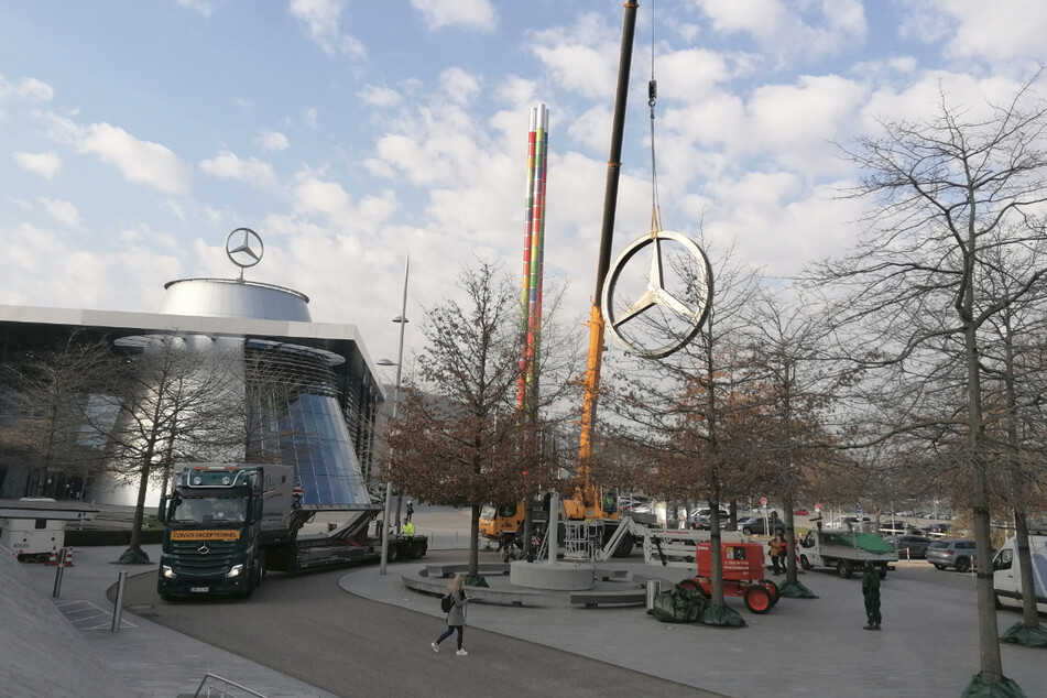 Der Mercedes-Stern wird mit einem Kran an seinen Zwischenlager-Platz gebracht.