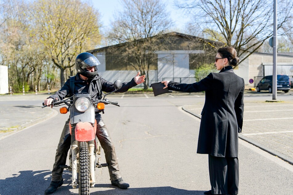 Simone übergibt einem unbekannten Biker eine Tasche mit Geld und Passfotos, die er ihr aus den Händen reißt und wegfährt.