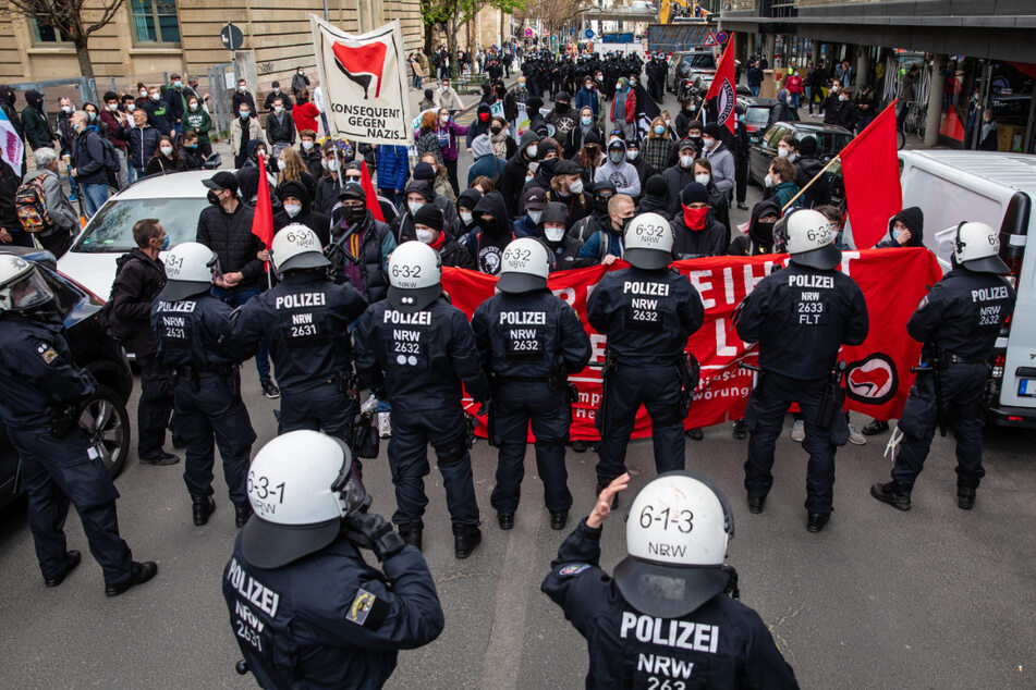 Polizisten stehen Gegendemonstranten der linksradikalen Antifa gegenüber.