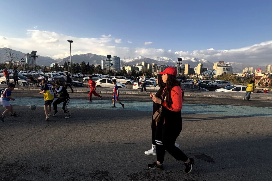 Women walk along the Pardisan Park as children play in Tehran, Iran, on April 5, 2026.