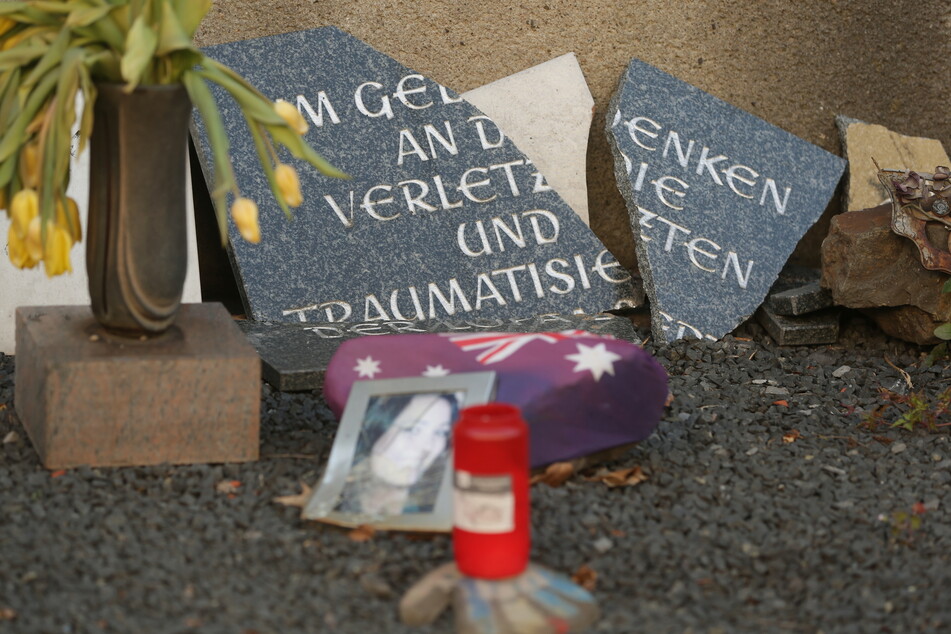 Eine zerbrochene Gedenktafel aus Stein an der Loveparade-Gedenkstätte.