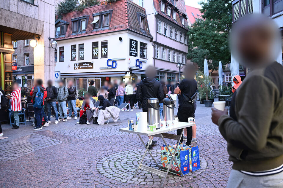 Die anstehenden Menschen versorgen sich mit Essen und Trinken.