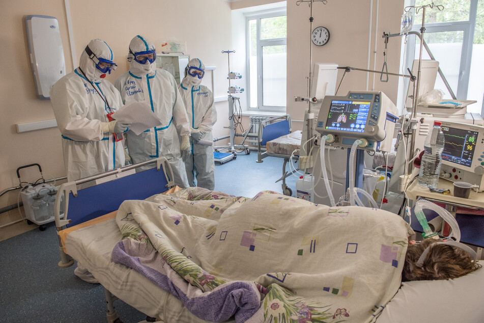Medizinisches Personal in Schutzanzügen kümmert sich um einen Covid-19-Patienten. (Archivbild)