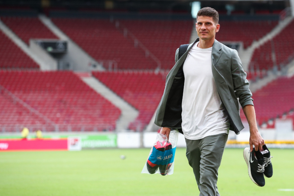 Mario Gomez (34) läuft nach seinem letzten Profispiel mit Schuhen in der Hand aus der Mercedes-Benz Arena in Stuttgart.