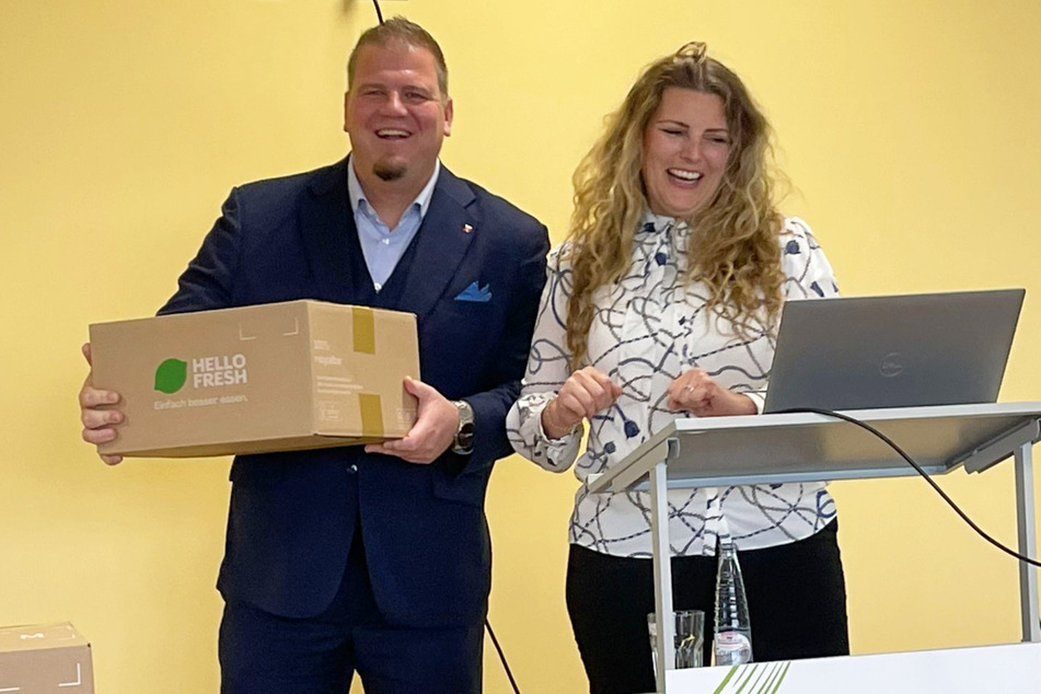Barlebens Bürgermeister Frank Nase (l., CDU) bekam von HelloFresh-Standortleiterin Michaela Smith die erste produzierte Kochbox überreicht.