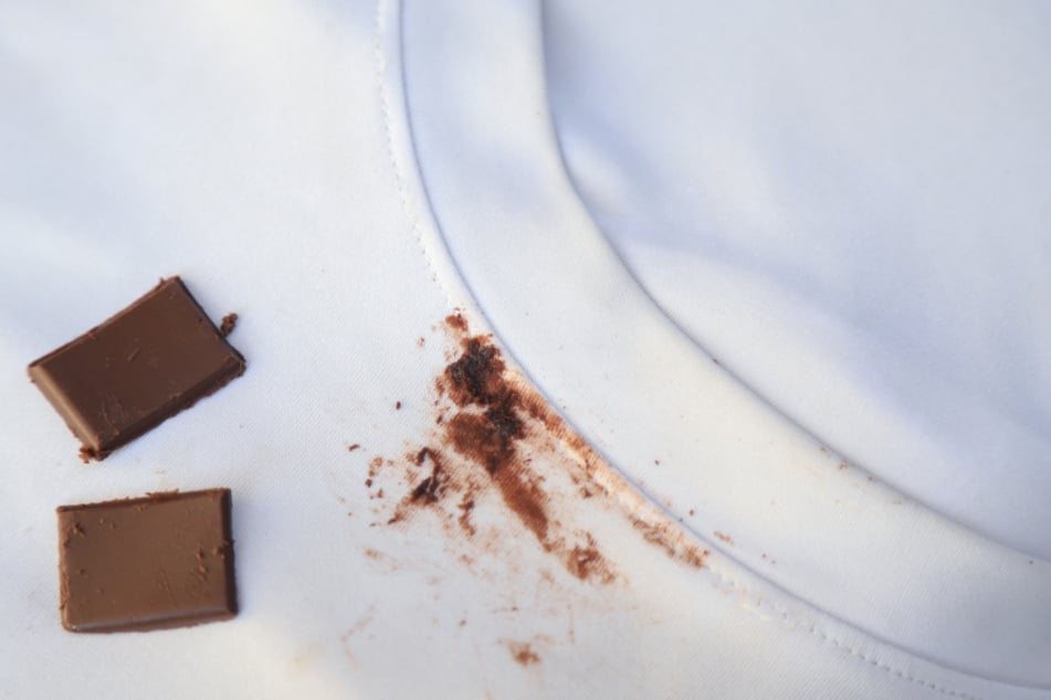 Bevor Du Schokoladenflecken von der Kleidung lösen kannst, solltest Du erst vorsichtig alle Schokoladenreste von der Oberfläche kratzen.