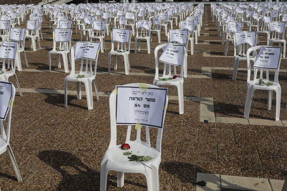 1000 Plastikstühle mit je einer roten Rose und einem Zettel mit dem Namen eines Menschen, der an Covid-19 verstorben ist, auf dem Rabin-Platz in Tel Aviv. Die Zahl der Todesfälle in Israel im Zusammenhang mit einer Corona-Infektion hat die Marke von 1000 überschritten.