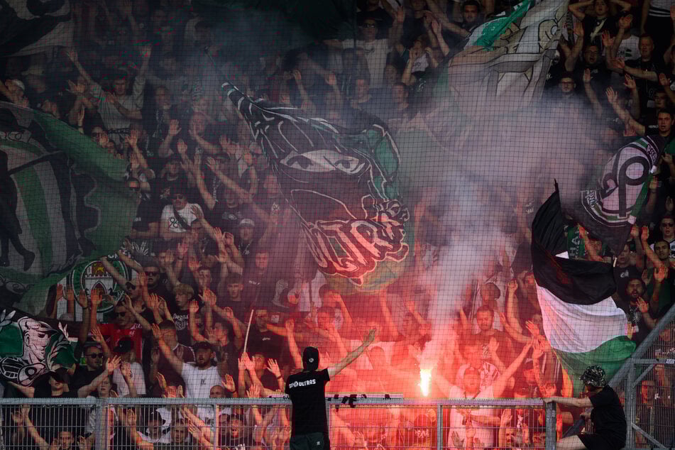Die Hannover-Fans zünden Pyrotechnik im Gästeblock. Zuvor verbrannten sie Cottbuser Fan-Utensilien.
