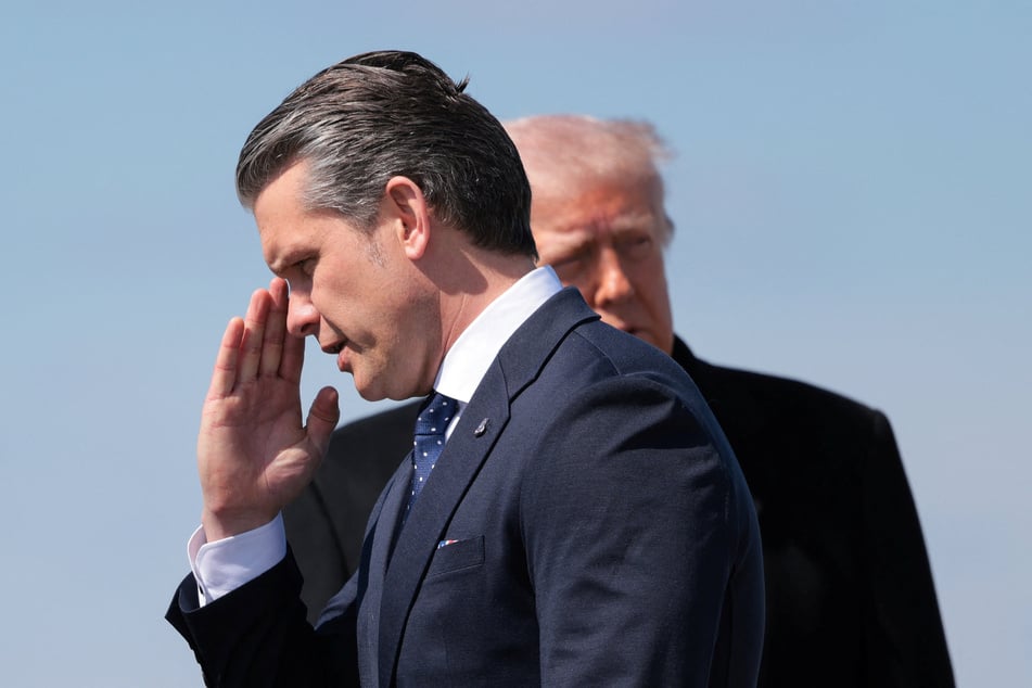 Secretary of Defense Pete Hegseth salutes as he and President Donald Trump arrive at Dover Air Force Base on March 18, 2026.