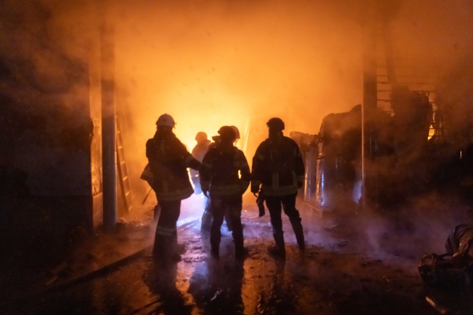 Rettungskräfte arbeiten nach einem russischen Angriff an einem brennenden Gebäude in Charkiw.