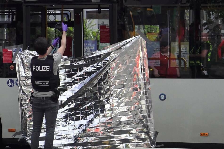 Ein Mitarbeiter der Kriminalpolizei fotografiert den Tatort einer Messerattacke in einem Linienbus.